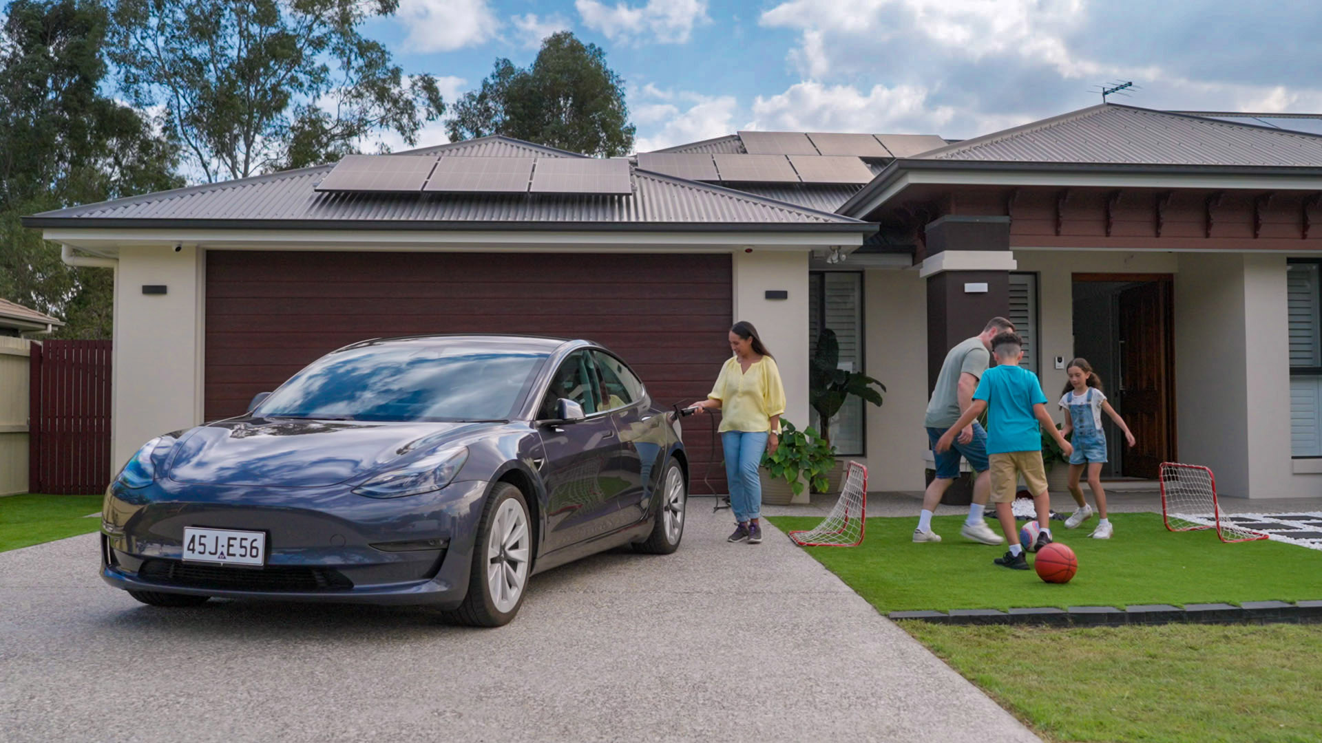 Family kicking ball front house