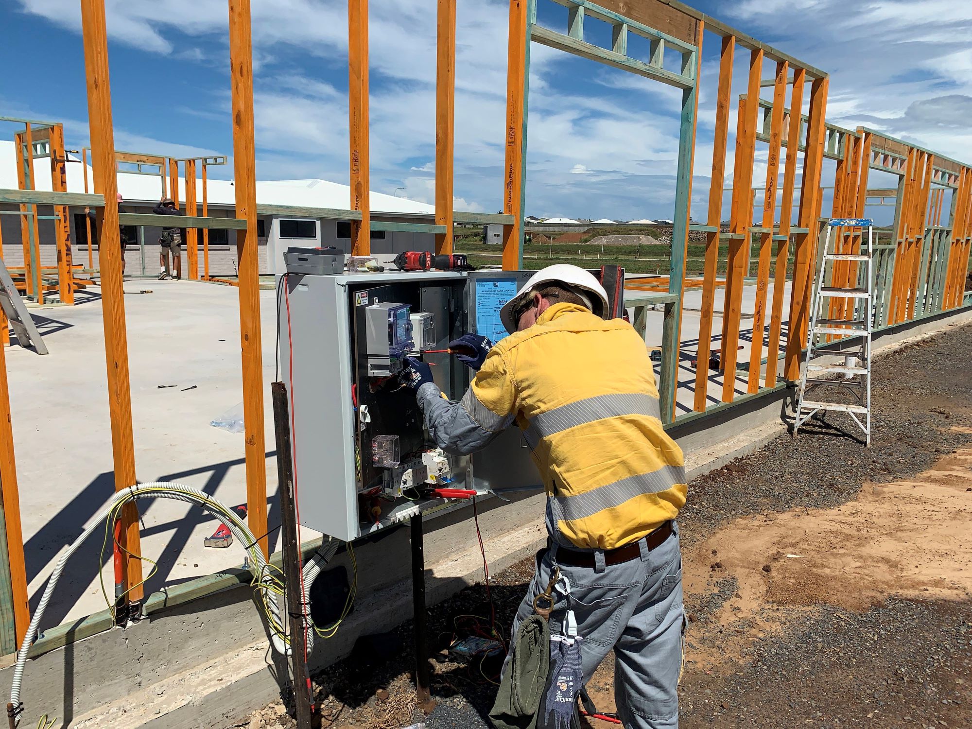 Worker installing a meter at a building site