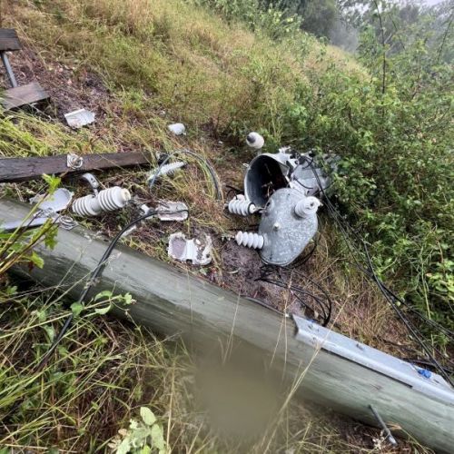 Power pole on ground with smashed transformer