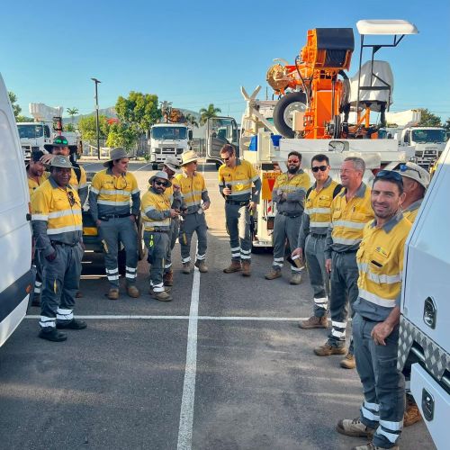 Field crews in parking lot with work vehicles