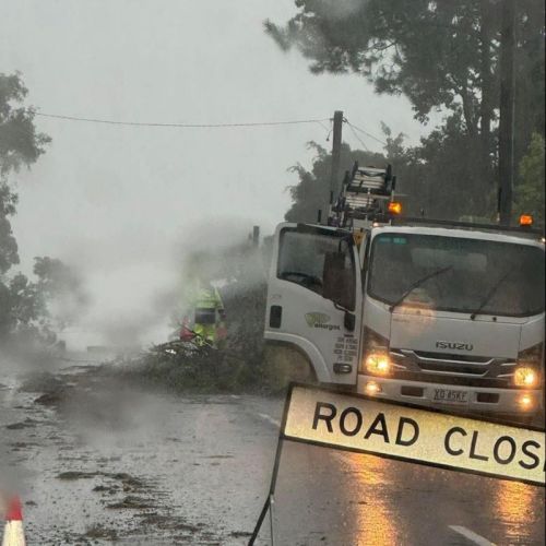 Work vehicle and crew members remove debris off the road