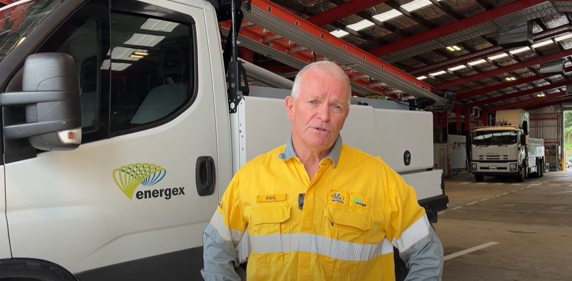 Paul Jordon in a depot standing in front of work vehicles